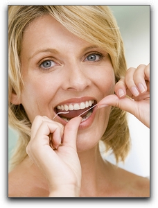 A girl cleaning her teeth with thread